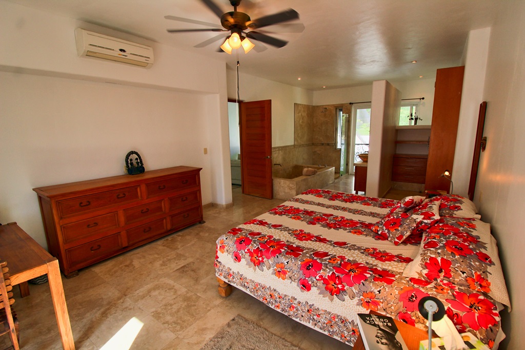 Master bedroom with king size bed, dresser, closet area.